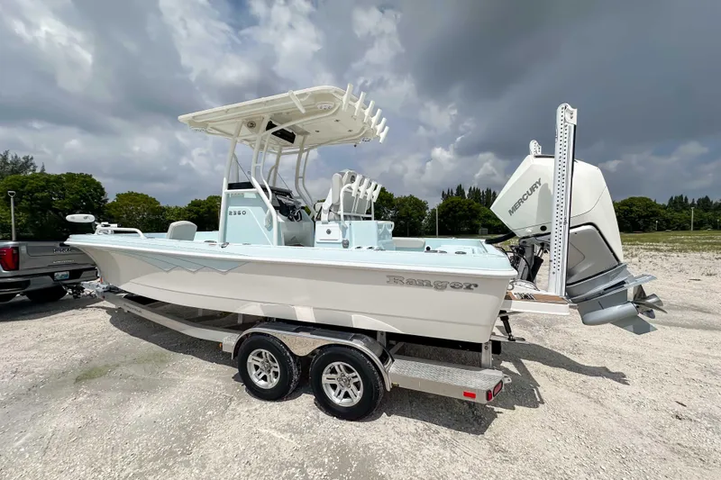 Slide: The Image of 2025 Ranger 2360 Bay boat on trailer, parked outdoors under cloudy sky. - 3