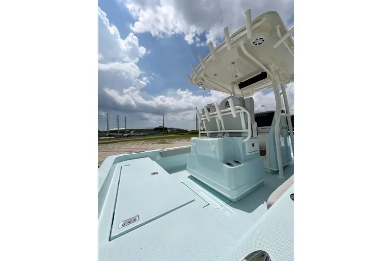 Slide: The Image of 2025 Ranger 2360 Bay boat interior with seating and storage under a cloudy sky. - 5