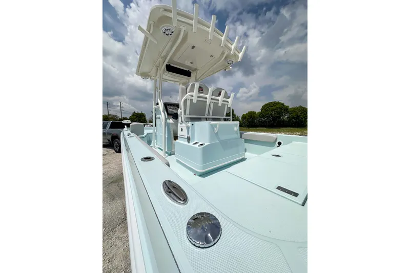 Slide: The Image of 2025 Ranger 2360 Bay boat with sleek design and spacious deck under cloudy sky. - 7