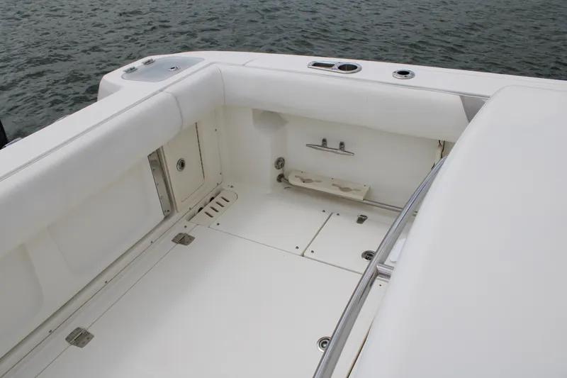 Slide: The Image of 2015 Boston Whaler 320 Outrage boat interior with white seating and storage compartments. - 22