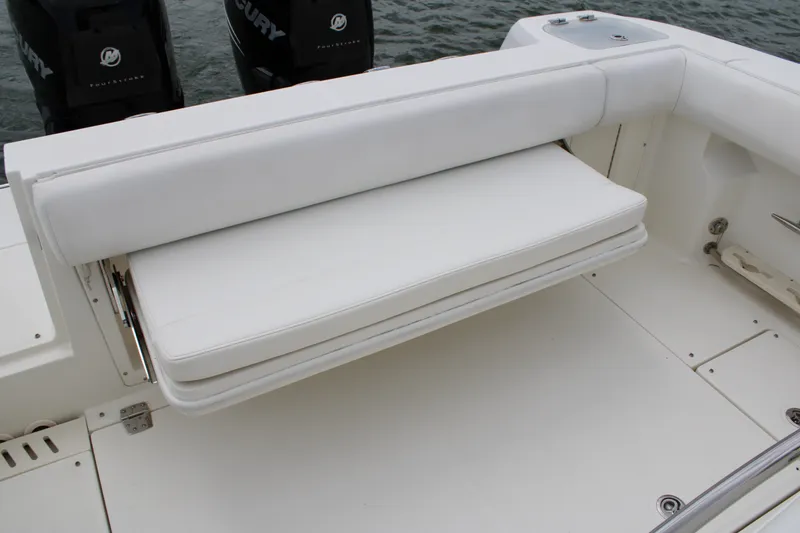 Slide: The Image of 2015 Boston Whaler 320 Outrage boat with white cushioned seating and dual Mercury engines. - 24