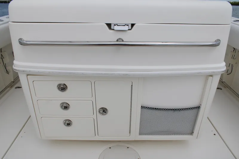 Slide: The Image of 2015 Boston Whaler 320 Outrage storage compartment with drawers and mesh pocket. - 26