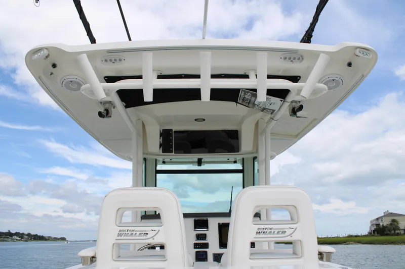 Slide: The Image of 2015 Boston Whaler 320 Outrage boat helm with seating, under a clear sky. - 29