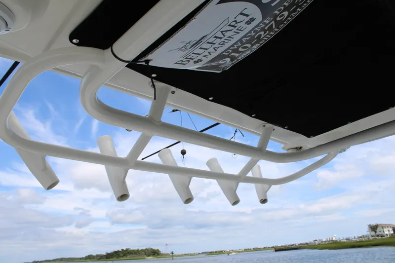 Slide: The Image of 2015 Boston Whaler 320 Outrage rod holders against a scenic sky and water backdrop. - 31