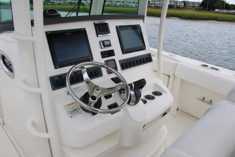 Slide: The Image of 2015 Boston Whaler 320 Outrage helm with dual screens and steering wheel. - 33