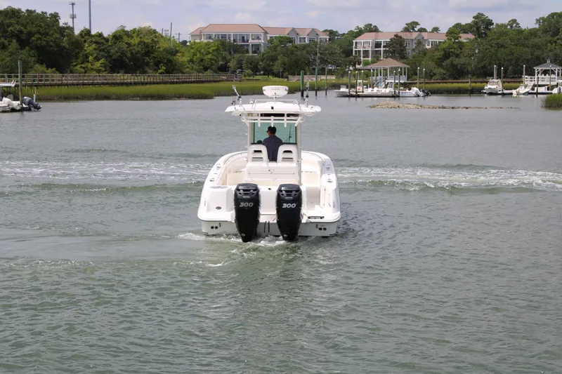Slide: The Image of 2015 Boston Whaler 320 Outrage cruising on a calm river near docks. - 4