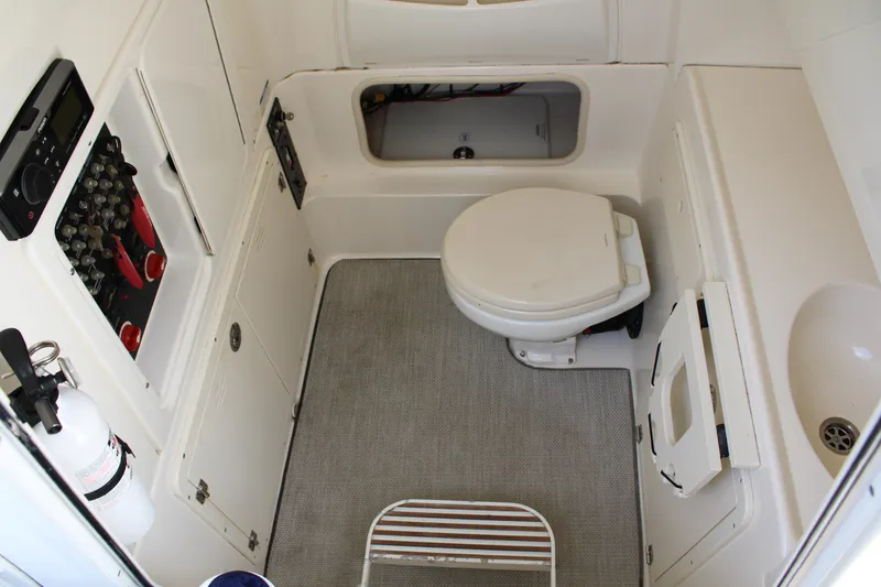 Slide: The Image of 2015 Boston Whaler 320 Outrage boat interior with toilet and control panel. - 42