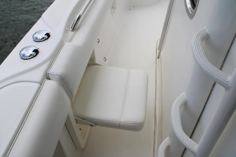 Slide: The Image of 2015 Boston Whaler 320 Outrage boat interior with white seating and chrome details. - 47