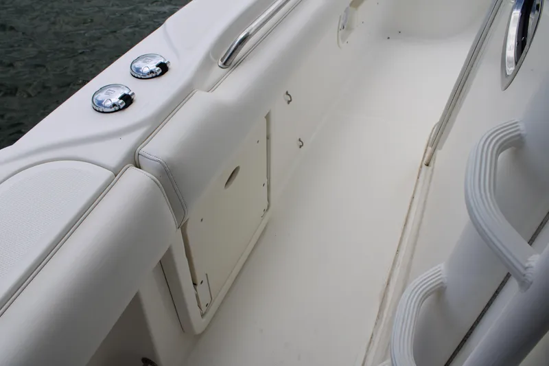 Slide: The Image of 2015 Boston Whaler 320 Outrage interior, featuring sleek white seating and chrome fixtures. - 48