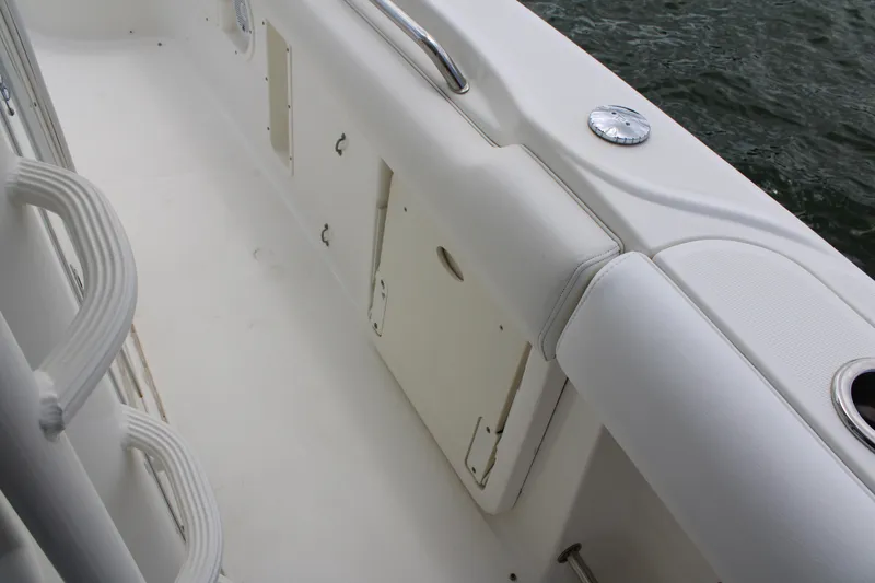 Slide: The Image of 2015 Boston Whaler 320 Outrage boat interior with white seating and storage compartments. - 50