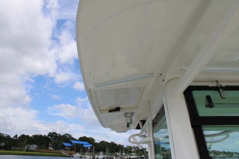 Slide: The Image of 2015 Boston Whaler 320 Outrage boat detail with blue sky and marina background. - 52