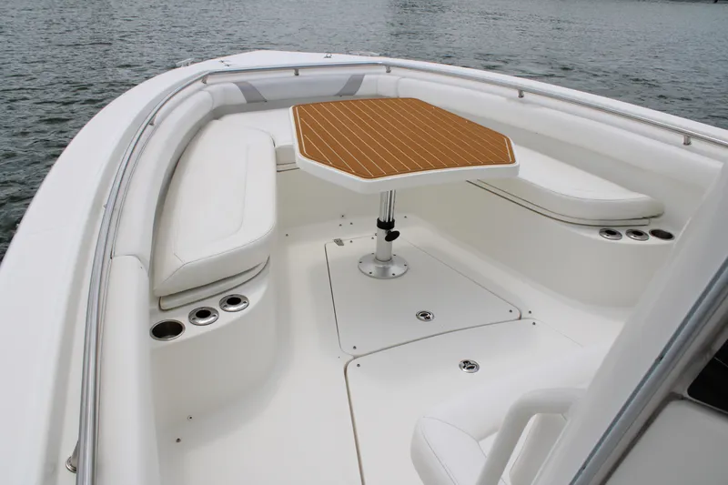 Slide: The Image of 2015 Boston Whaler 320 Outrage boat interior with seating and table on water. - 55