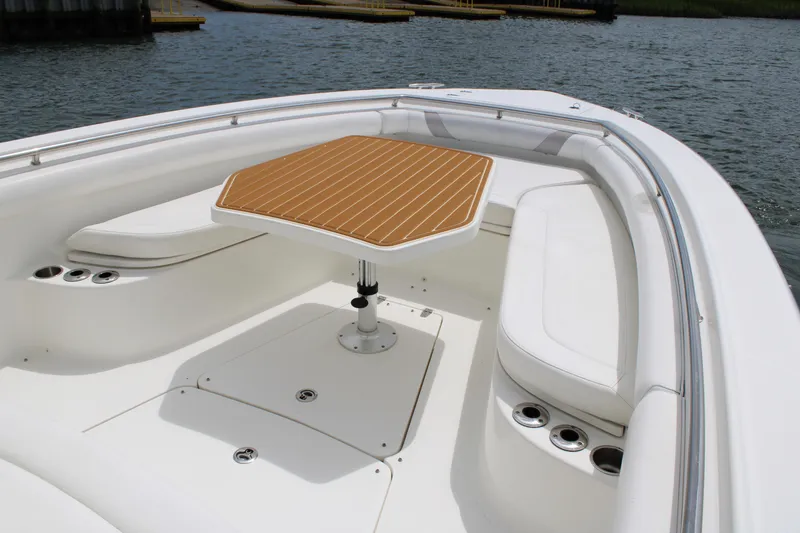 Slide: The Image of 2015 Boston Whaler 320 Outrage boat interior with seating and table on water. - 56