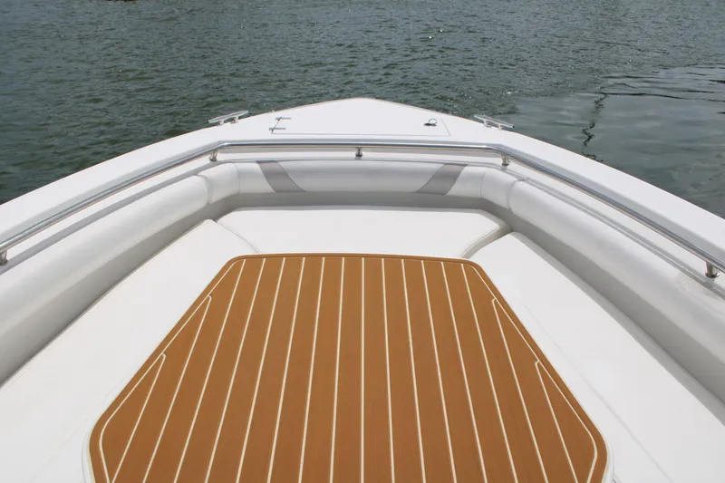 Slide: The Image of 2015 Boston Whaler 320 Outrage boat deck with cushioned seating and teak flooring. - 57