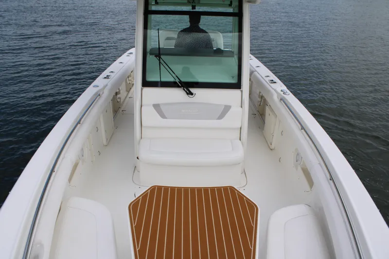 Slide: The Image of 2015 Boston Whaler 320 Outrage boat interior with seating and deck, on calm water. - 59