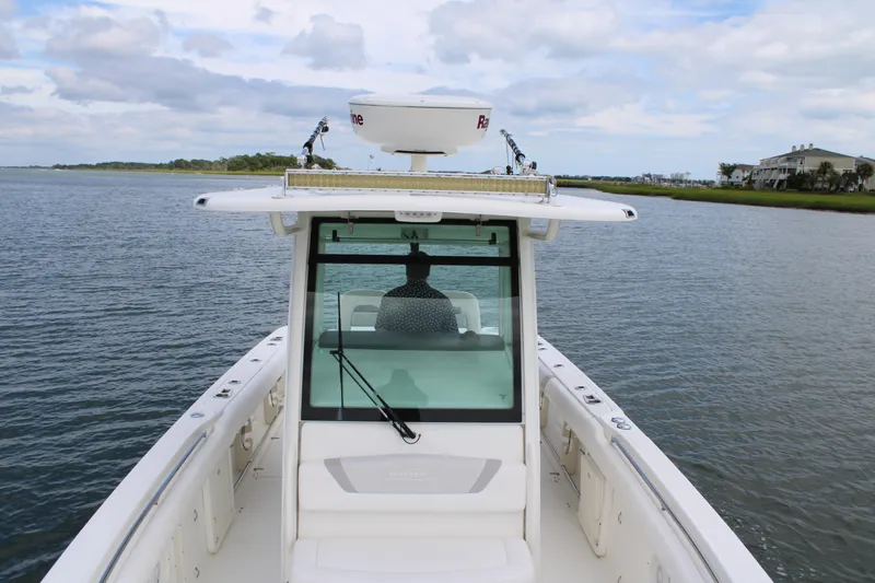 Slide: The Image of 2015 Boston Whaler 320 Outrage cruising on calm waters under a cloudy sky. - 60