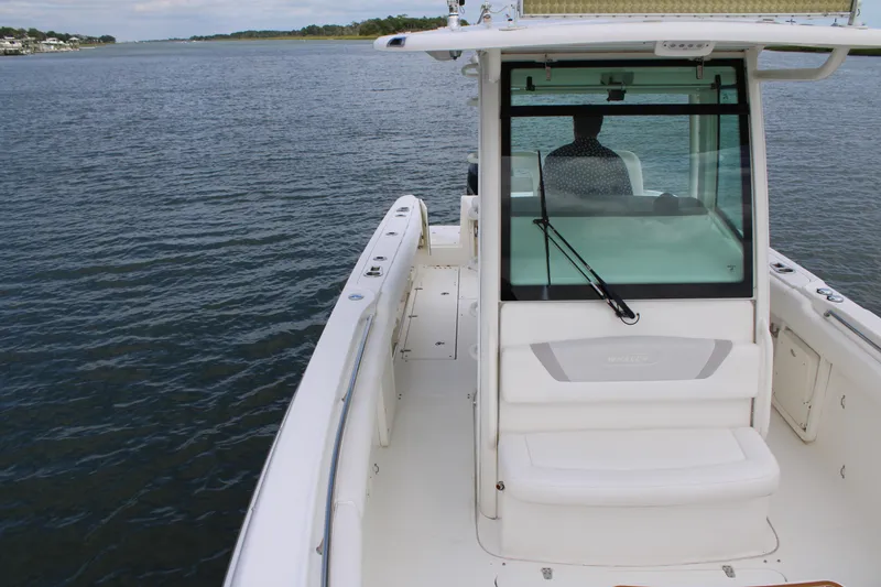 Slide: The Image of 2015 Boston Whaler 320 Outrage boat on calm water, showcasing helm and seating area. - 61