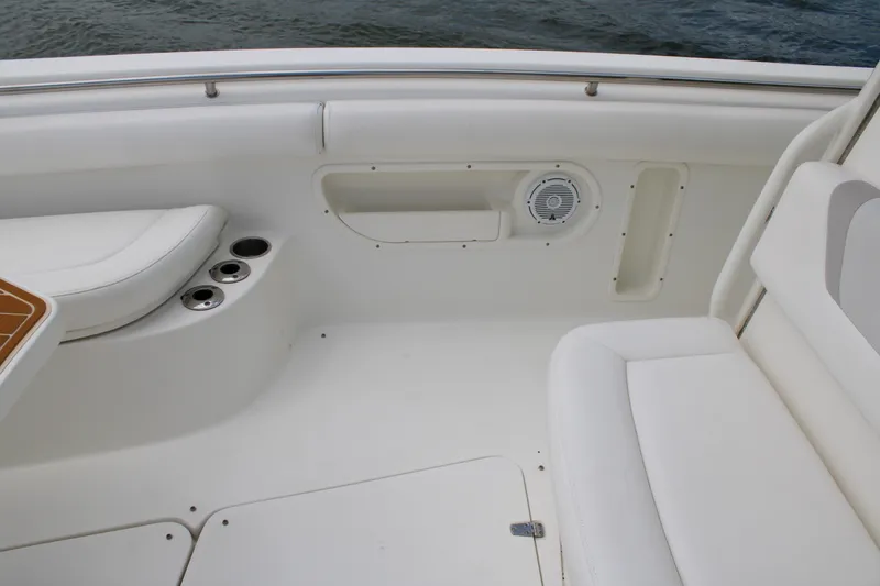 Slide: The Image of Interior view of a 2015 Boston Whaler 320 Outrage boat, featuring white seating and cup holders. - 64