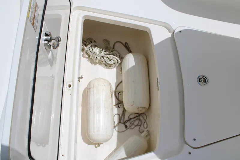 Slide: The Image of Storage compartment on a 2015 Boston Whaler 320 Outrage with ropes and fenders. - 66