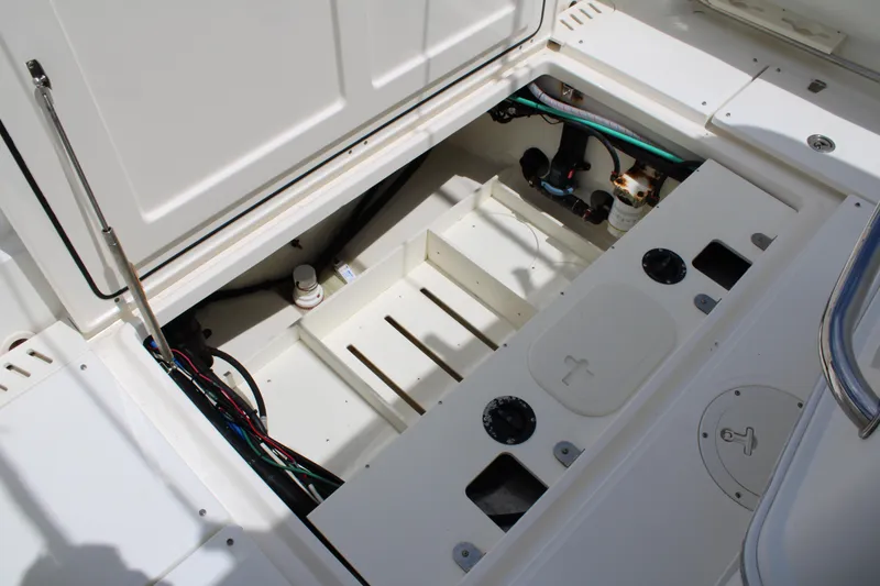 Slide: The Image of 2015 Boston Whaler 320 Outrage boat storage compartment with visible wiring and components. - 67