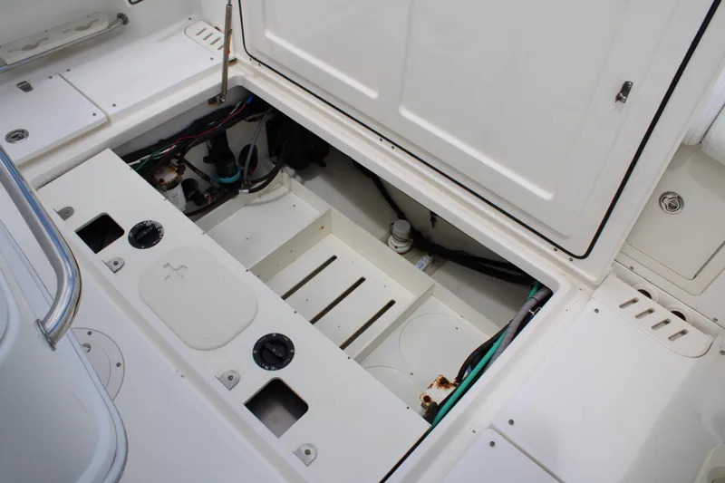 Slide: The Image of 2015 Boston Whaler 320 Outrage boat storage compartment with open hatch and visible wiring. - 68