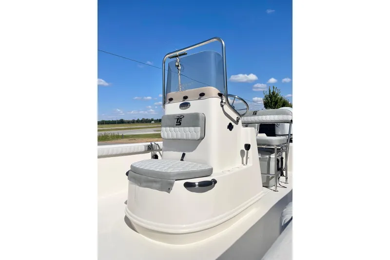 Slide: The Image of 2026 Carolina Skiff 21 LS boat console with seating, under a clear blue sky. - 15