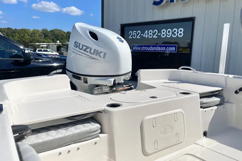Slide: The Image of 2026 Carolina Skiff 21 LS boat with Suzuki outboard motor, displayed outdoors. - 21