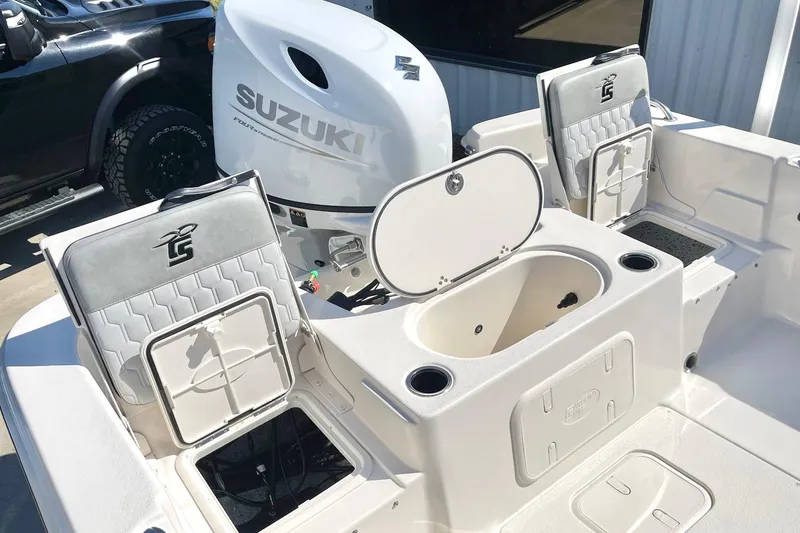 Slide: The Image of 2026 Carolina Skiff 21 LS boat interior with Suzuki engine, featuring seating and storage compartments. - 23