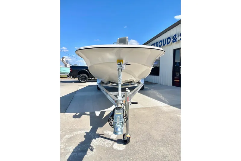 Slide: The Image of 2026 Carolina Skiff 21 LS boat on trailer, parked outside dealership under clear blue sky. - 5