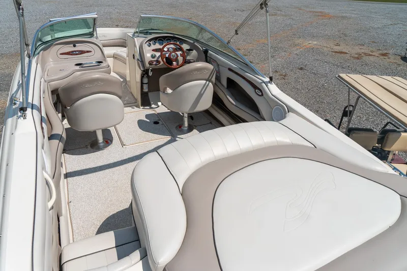 Slide: The Image of 2002 Sea Ray 230 Bow Rider interior with beige seating and modern dashboard. - 11