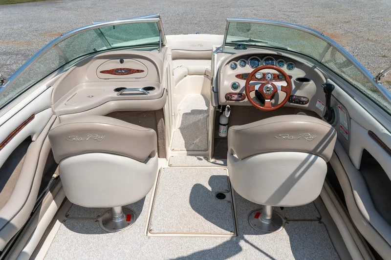 Slide: The Image of 2002 Sea Ray 230 Bow Rider interior with steering wheel and seating, showcasing luxury design. - 13