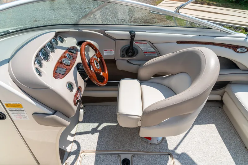 Slide: The Image of 2002 Sea Ray 230 Bow Rider cockpit with steering wheel and control panel. - 17