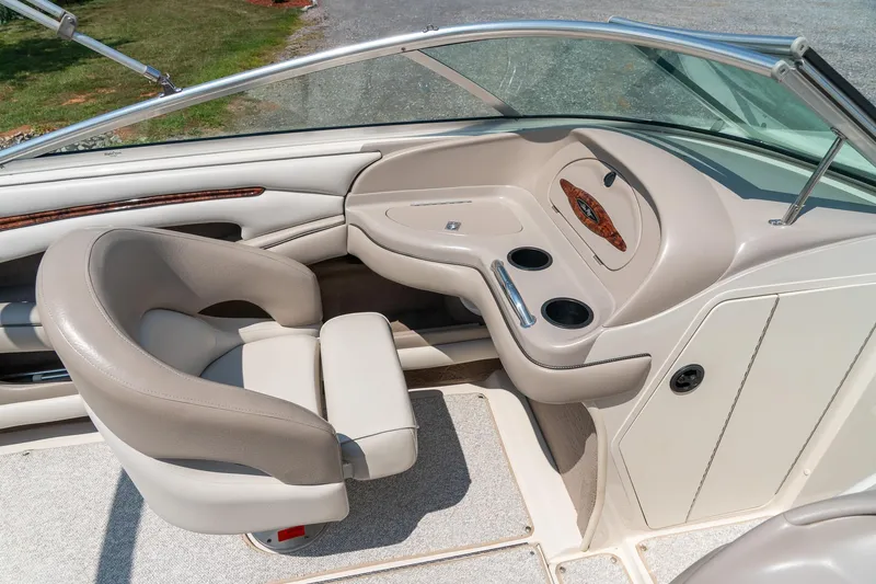 Slide: The Image of 2002 Sea Ray 230 Bow Rider interior with beige seating and dashboard details. - 18