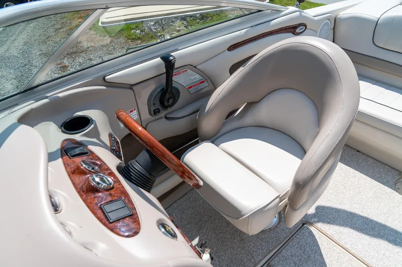 Slide: The Image of 2002 Sea Ray 230 Bow Rider interior with steering wheel and comfortable seating. - 22