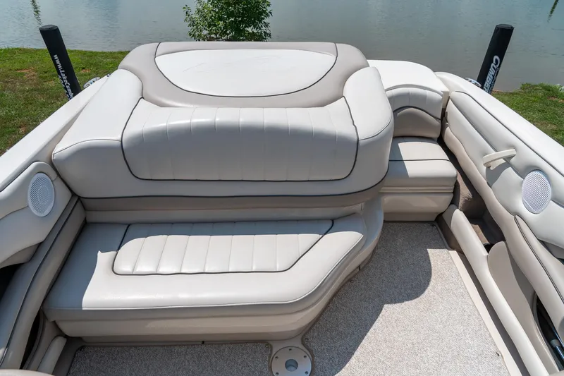 Slide: The Image of 2002 Sea Ray 230 Bow Rider interior with plush seating and lake view. - 25