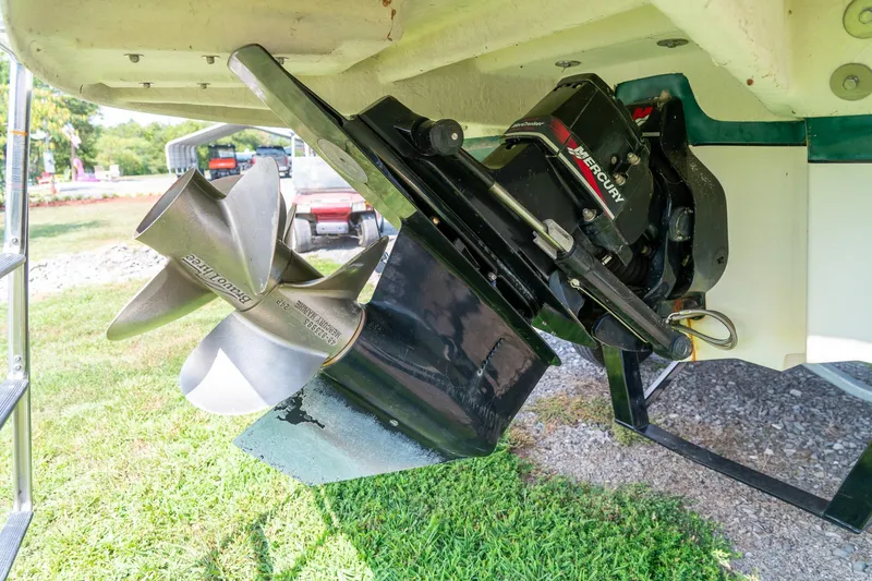 Slide: The Image of 2002 Sea Ray 230 Bow Rider boat propeller and Mercury outdrive on grass. - 28
