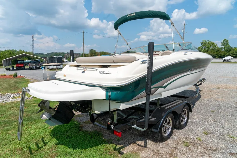 Slide: The Image of 2002 Sea Ray 230 Bow Rider boat on trailer, parked outdoors under a blue sky. - 3