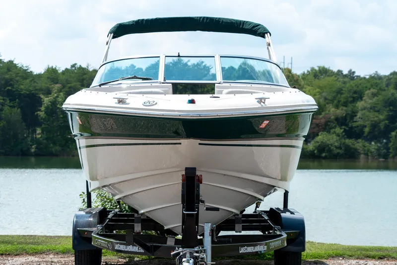 Slide: The Image of 2002 Sea Ray 230 Bow Rider boat on trailer by a lake. - 4