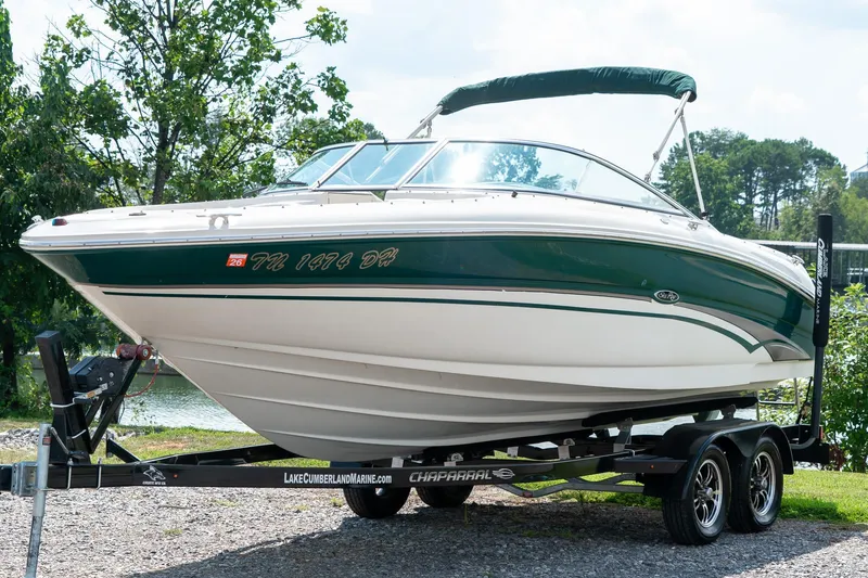 Slide: The Image of 2002 Sea Ray 230 Bow Rider boat on trailer, green and white design, parked outdoors. - 5