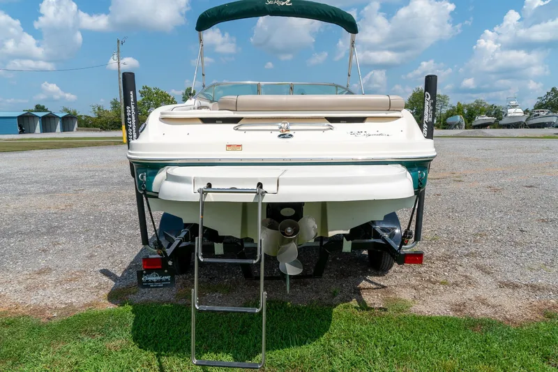 Slide: The Image of 2002 Sea Ray 230 Bow Rider boat, rear view with ladder, parked on grass. - 8