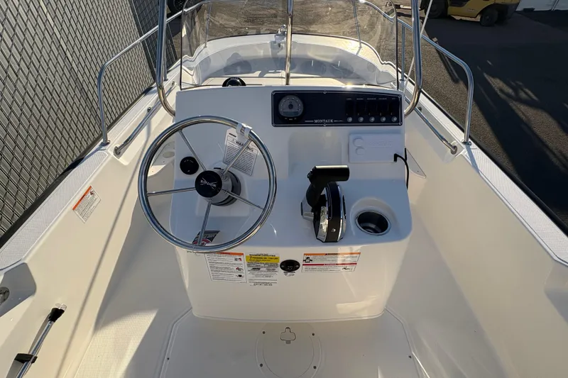 Slide: The Image of 2026 Boston Whaler 170 Montauk boat console with steering wheel and controls. - 6