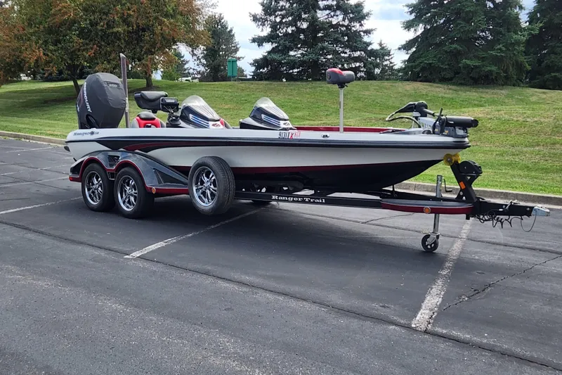 Slide: The Image of 2015 Ranger Z521 Comanche boat on trailer in parking lot, surrounded by greenery. - 0