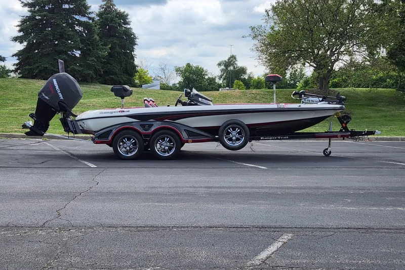 Slide: The Image of 2015 Ranger Z521 Comanche boat on trailer in parking lot, surrounded by greenery. - 18