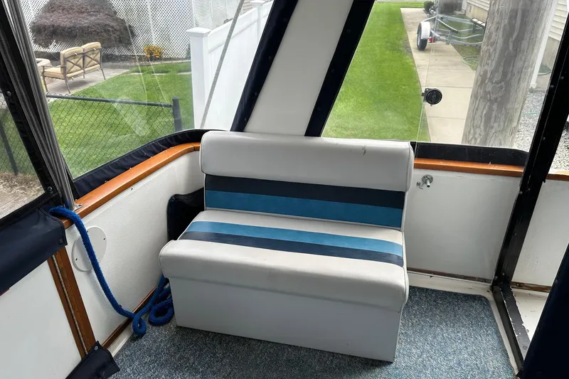 Slide: The Image of 1989 Sea Ray 380 Aft Cabin interior with striped seating and outdoor view. - 12