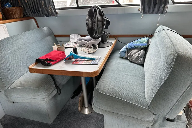 Slide: The Image of Cozy dining area inside a 1989 Sea Ray 380 Aft Cabin yacht with fan and seating. - 14