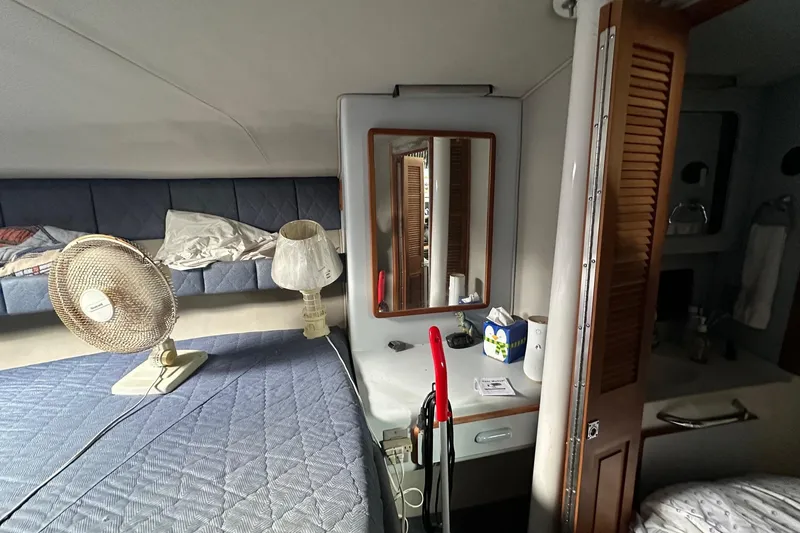 Slide: The Image of 1989 Sea Ray 380 Aft Cabin interior with bed, fan, and vanity area. - 15