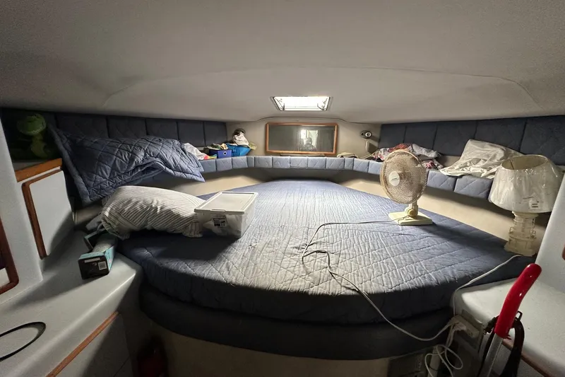Slide: The Image of 1989 Sea Ray 380 Aft Cabin interior with bed, fan, and lamp. Cozy marine cabin. - 19
