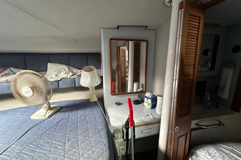 Slide: The Image of 1989 Sea Ray 380 Aft Cabin interior with bed, fan, and vanity area. - 20