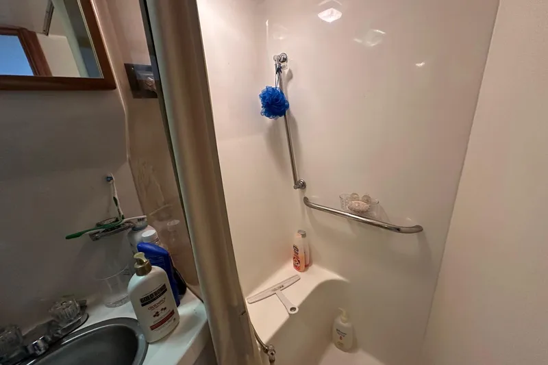 Slide: The Image of Shower area in 1989 Sea Ray 380 Aft Cabin with toiletries and grab bar. - 24