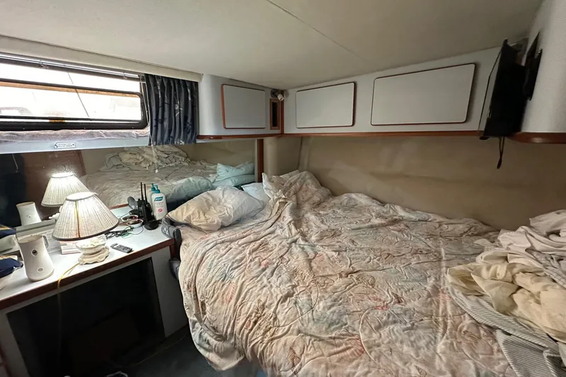 Slide: The Image of 1989 Sea Ray 380 Aft Cabin bedroom with bed, lamp, and storage cabinets. - 26